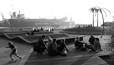011_25909 | junge Leute sitzen in der Abendsonne im Antonipark / park fiction mit den knstlichen Palmen und Blick auf die Elbe mit dem Dock 11 der Werft Blohm + Voss.