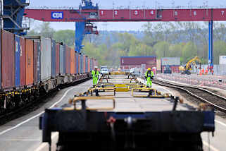 8476 Die Ladung eines Containerzugs wird im Containerbahnhof Hamburg Altenwerder gelscht - einer der Container wird mit einem Portalkran vom Gterwaggon zum Sattelauflieger transportiert. 