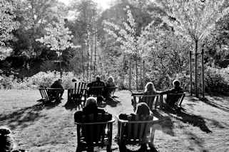 6726 Herbstnachmittag im Hamburger Stadtpark - alle Holzsthle auf der Liebesinsel am Stadtparksee sind besetzt - die BesucherInnen sonnen sich / Schwarz-Wei Aufnahme. 