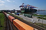 011_25941 | Blick zum Eurogate Terminal am Waltershofer Hafen - ein beladener Container Carrier liegt am Kai - im Vordergrund ein langer Containerzug und auf der Strasse Lastwagen mit ihrer Containerladung.