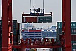 011_25943 | zwei Standartcontainer  hngen an den Haken der Laufkatze der Containerbrcke - im Hintergrund ein Verwaltungsgebude der HHLA am Burchardkai und die Silhouette von der Hansestadt Hamburg