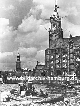 019_93804 | Elbseite des Speicher- gebudes; Schlepper fahren zu ihrem Liegeplatz - im Hintergrund der Turm der St. Michaeliskirche. (ca. 1925) 