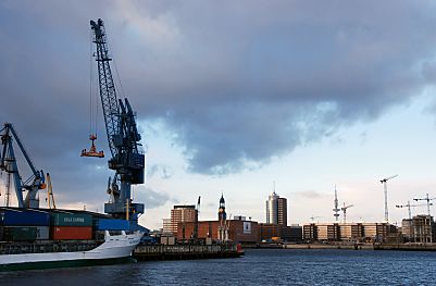 011_25897 | im Südwesthafen entlädt ein Kran ein Containerschiff / Feeder; im Hintergrund das Hamburg Panorama: lks. der Kaispeicher A, dahinter der Michel und rechts davon der Büroturm vom HTC am Kehrwieder - rechts davon der Fernsehturm und die Baukrane der entstehenden Hafencity.