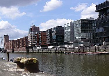 011_25863 | Blick vom Kaiserkai zum Sandtorkai; im Hintergrund lks. das Hanseatic Trade Center an der Kehrwiederspitze; im Vordergrund Eisenpoller an der Kaimauer, an der frher die Schiffe im Sandtorhafen fest gemacht haben.