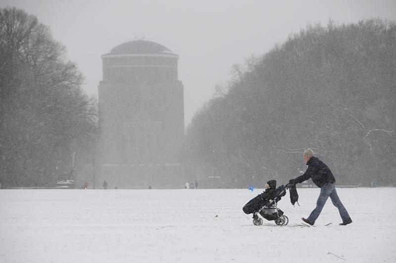 Hamburg Bilder im Winter - Schneefall im Hamburger Stadtpark; Planetarium, Spaziergnger. 108_5054 |Dichtes Schneetreiben im Stadtpark von Hamburg-Winterhude. Ein Spaziergnger schiebt seine Kinderkarre durch den Schnee - im Hintergrund das massive Gebude des Planetariums. www.fotograf-hamburg.de