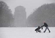 108_5054 | Dichtes Schneetreiben im Stadtpark von Hamburg-Winterhude. Ein Spaziergnger schiebt seine Kinderkarre durch den Schnee - im Hintergrund das massive Gebude des Planetariums. 