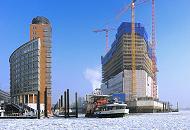 110_5304 | Baukrne ragen an der Baustelle der zuknftigen Elbphilharmonie in den blauen Winterhimmel. Eine Hafenfhre legt gerade vom Anleger Sandtor ab und fhrt durch das dichte Treibeis Richtung St. Pauli Landungsbrcken. 