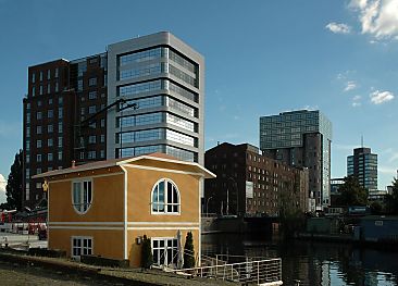 011_25821 | Architektur am Binnenhafen von Hamburg- Harburg. Ganz im Hintergrund liegt der sogen. Channeltower, davor das zu einem Brogebude umgebautes Silo. Danach folgt die denkmalgeschtzte Industriearchitektur der Harburger lmhle und dann der umgebaute Kaispeicher am Veritaskai. Im Vordergrund ein modernes Hausboot. 