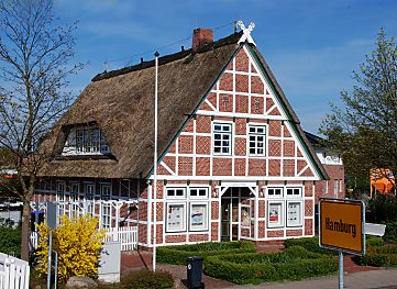 011_25921 |  Fachwerkhaus, mit Reet gedeckt an Hamburgs Stadtgrenze im Alten Land; das gelbe Schild mit der Aufschrift Hamburg am Strassenrand weist den Autofahrer darauf hin. 