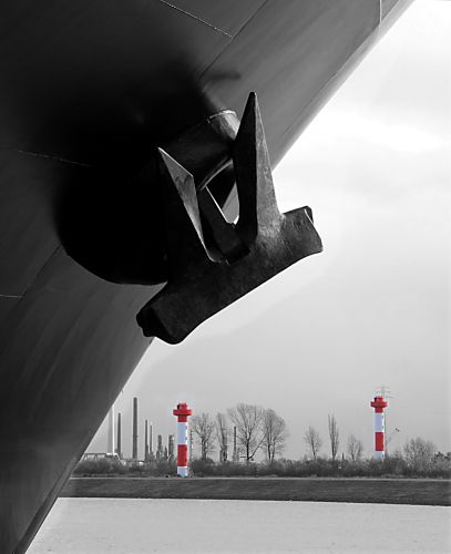 011_25989 | dam Bug des Containerschiffs am Ballinkai des Hamburger Hafen Terminals Altenwerder der mächtige Anker; im Hintergrund die Richtfeuer /Leuchtfeuer / Leuchttürme, die die von der Elbe kommenden Frachtschiffe die Richtung weisen.