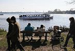 011_25609 | eine Familie sitzt mit ihren Kindern auf einer sonnigen Bank am Alsterufer Hhe Bellevue und geniesst den Ausblick ber die Alster. Ein Alsterdampfer kommt vom Langen Zug und fhrt weiter Richtung Krugkoppelbrcke.