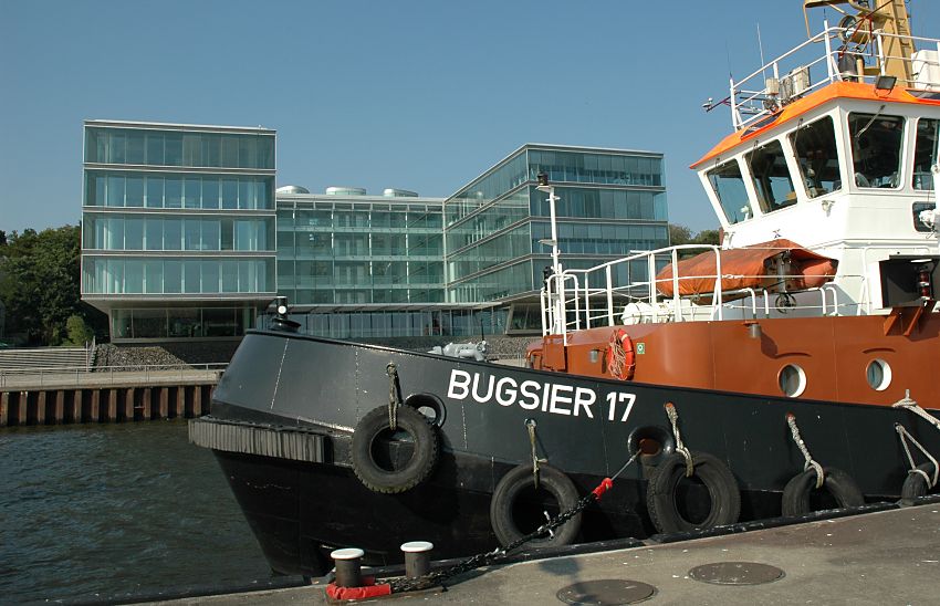 011_26030 |Bilder von Hamburg ::  Der Schlepper BUGSIER 17 hat am Anleger in Hamburg Neumhlen fest gemacht; die dicken Tampen sind um den eisernen Poller am Steg gelegt. Gummireifen dienen als Fender und sollen den Stoss beim Anlegen abfedern. Im Hintergrund die moderne Architektur am Elbufer von Hamburg Neumhlen.  www.christoph-bellin.de