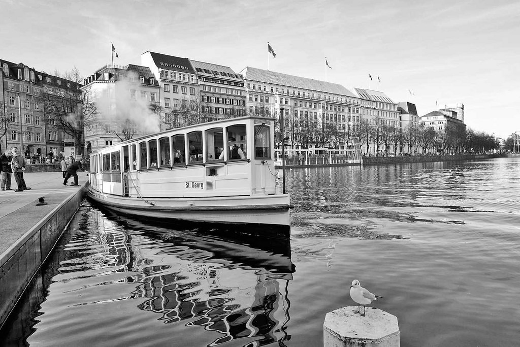 6317 Alsterdampfer St. Georg am Anleger Jungfernstieg - im Hintergrund das Hotel Vier Jahreszeiten und Gebude am Neuen Jungfernstieg. Das Alsterdampfschiff St. Georg ist das lteste noch fahrtchtige Dampfschiff Deutschlands und wurde 1876 auf der Reiherstiegwerft in Hamburg gebaut. Seit 1994 verkehrt die St. Georg in der Sommersaison als Alsterdampfer auf der Hamburger Alster.