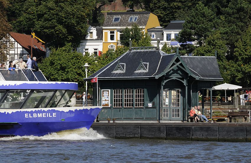 011_26036 |  Fotos von Hamburg - Bilder von der Elbe :: Schiffsanleger am Museumshafen in Hamburg Oevelgoenne - die Hafenfhre ELBMEILE  in Fahrt mit Bugwelle; ds Fhrschiff legt gleich am Ponton an. Das historische Wartehuschen aus Holz ist Teil des Museumshafens, der sich hinter dem Anleger befindet. Im Hintergrund die historischen Huser von Oevelgoenne.   www.christoph-bellin.de