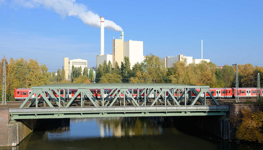 7314 Blick von der Tiefstacker Brcke auf den Tiefstackkanal; ein S-Bahnzug berquert die Eisenbahnbrcke - Rauch steigt aus einem Schornstein der Mllverwertungsanlage MVA Borsigstrasse in Hamburg Billbrook.