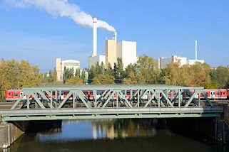 7314 Blick von der Tiefstacker Brcke auf den Tiefstackkanal; ein S-Bahnzug berquert die Eisenbahnbrcke - Rauch steigt aus einem Schornstein der Mllverwertungsanlage MVA Borsigstrasse in Hamburg Billbrook.