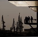 011_26042 |  Abenddmmerung im  Hamburger Hafen - Krane stehen sind als Silhouette an Hamburgs Abendhimmel zu sehen. Hamburg-Touristen stehen auf der Aussichtsplattform in der Hafencity am Sandtorhafen und blicken auf die Elbe.  www.christoph-bellin.de 