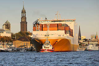 7520 Das RoRo Frachtschiff Grande Angola verlsst den Hambuger Hafen; mit Hilfe von Schleppern wird der Frachter in die Fahrrinne geschleppt. Links vom Schiff die Kuppel vom alten Elbtunnel und der Kirchturm der St. Michaeliskirche 