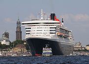 96-4382 | Die Queen Mary 2 verlsst den Hafen der Hansestadt Hamburg. Im Hintergrund der hohe Kirchturm des Hamburger Wahrzeichens, die St. Michaeliskirche. Die R.M.S. (Royal Mail Ship)  Queen Mary 2 (QM2) ist mit 148.528 BRZ eines der grten Passagierschiff der Welt. Das britische Kreuzfahrtschiff  hat eine Lnge von 345 m und eine Breite von 45 m. Der Luxusliner bietet in 1310 Kabinen bis zu 2.620 Passagieren Platz und hat eine Besatzung von 1.253 Personen. Die Queen Mary 2 hat fnf Swimmingpools, einen Ballsaal, Golfanlage, Wintergarten, Sportzentrum, mit ber 8.000 Bchern die grte Bibliothek auf See, den grten ffentlichen Saal (Restaurant Britannia), der ber zwei Decks und die gesamte Schiffsbreite geht, acht weitere Restaurants, Fitness-Center, Planetarium, Kino, Theater. www.fotograf- hamburg.de 