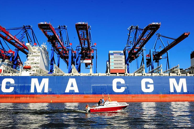 1150_1138 Das Containerschiff CMA CGM CHRISTOPHE COLOMB liegt am Burchardkai des Hamburger Hafens unter den weit ausladenden Containerbrcken des HHLA Container Terminals - ein Sportboot fhrt durch den Waltershofer Hafen, einem der Hafenbecken im Hamburger Hafengebiet. Der Hamburger Hafen hat eine Flche von 7236 Hektar. Er ist der grte Seehafen in Deutschland und, nach den Hfen von Rotterdam und Antwerpen, der drittgrte in Europa. Der Hafen bietet 320 Liegepltze fr Seeschiffe an 35 Kilometer Kaimauer, davon 38 Groschiffsliegepltze fr Container- und Massengutschiffe sowie 97 Liegepltze an Dalben. Bei Containerschiffen wird die Lade- bzw. Stellplatzkapazitt in Anzahl der Container angegeben. Maeinheit ist die TEU (Twenty-foot Equivalent Unit). Damit ist ein Standard-Container von 20 Fu Lnge gemeint. Ein Containerschiff mit 6.000 TEU verfgt also ber Stellpltze fr 6.000 20-Fu-Container, bei optimaler Verteilung der Gewichte der einzelnen Container.