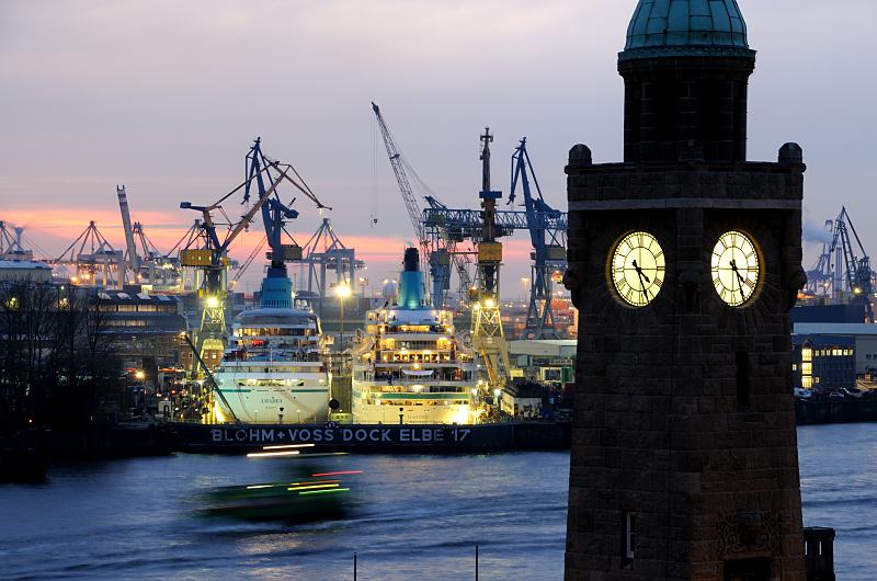 101_4525 |Blick von den St. Pauli Landungsbrcken ber die Elbe zum Blohm + Voss Dock Elbe 17. Die beiden Passagierschiffe AMADEA und ALBATROSS haben fr Wartungsarbeiten in der Hamburger Werft eingedockt. Die Schiffe sind hell angestrahlt - es wird auch nachts an ihnen gearbeitet. Im Vordergrund der Uhrturm / Pegelturm; die Zifferbltter sind erleuchtet. www.fotograf-hamburg.de