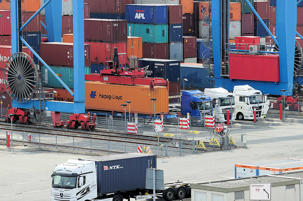 8240 Sattelschlepper / LKW stehen unter dem Portalkran auf dem Gelände vom Hamburger Container Terminal Altenwerder.