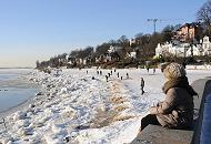 113_5730 | Die Hamburger geniessen die Wintersonne im Schnee am Elbstrand. Spaziergnger gehen vor Oevelgnne im Schnee an der Elbe entlang. Grosse Eisschollen liegen am Ufer des Hamburger Flusses.