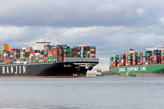 7788 Der Containerfrachter Hanjin Asia fährt auf der Elbe bei Stade - daneben die festgefahrene, havarierte CSCL Indian Ocean. 