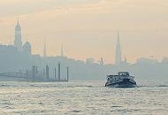 127_3830 | Hamburg Panorama kurz vor Sonnenaufgang; das Hamburger Panorama mit den markanten Kirchtrmen sind im Morgendunst, der ber der Elbe liegt schon zu erkennen. Eine Barkasse bringt Hafenarbeiter an ihren Arbeitsplatz. 