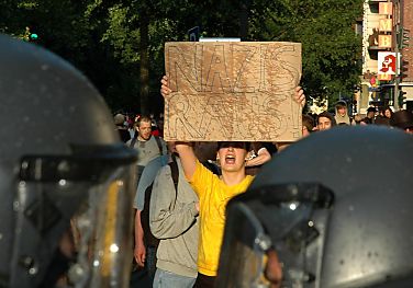 011_25935 | eine Anwohnerin von Hamburg Eimsbttel protestiert gegen eine Ansammlung von Rechtradikalen - sie steht vor einer Polizeikette und hlt ein Plakat  "Nazis raus!".  