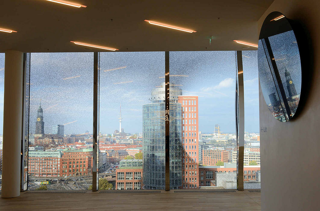 4978 Ausblick auf das Hamburg Panorama durch ein Fenster der Elbphilharmonie - im Vordergrund der Broturm am Kehrwieder + lks. der Kirchturm der St. Michaeliskirche ehem.? Wahrzeichen der Hansestadt Hamburg.