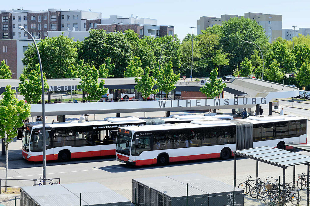 0396 Blick auf den Busbahnhof Hamburg Wilhelmsburg - ein Gelenkbus steht an der Haltestelle, ein weiterer Bus fährt ab.