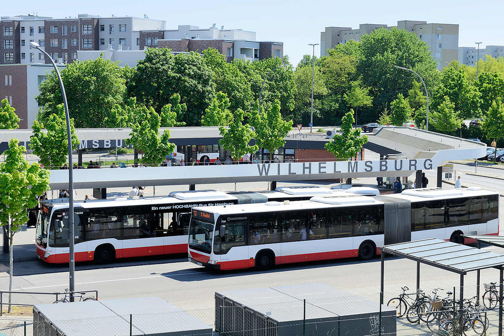 0396 Blick auf den Busbahnhof Hamburg Wilhelmsburg - ein Gelenkbus steht an der Haltestelle, ein weiterer Bus fhrt ab.