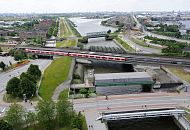 92-0043 |Fotografien aus den Hamburger Stadtteilen - Luftbild von der Veddel, Spreehafen, Hansahafen. Im Vordergrund hinter der Wilhelmsburger Brcke das Mggenburger Sperrwerk und die S-Bahnstation Veddel - ein roter S-Bahnzug steht an der Haltestelle. Die Backstein- Wohnhuser auf der linken Bildseite gehren noch zum Stadtteil Veddel, dahinter beginnt Hamburg-Wilhelmsburg. Der Spreehafen im Bildzentrum und der Hansahafen lks. sind Teil des Stadtteils Kleiner Grasbrook. www.fotograf- hamburg.de