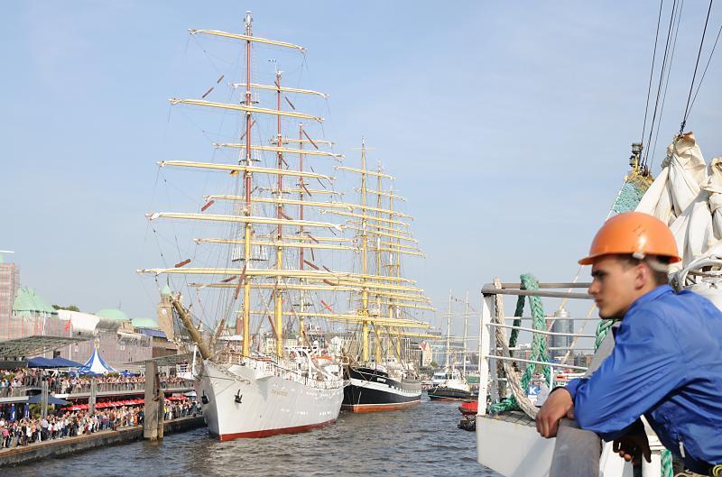 3203 | Ein Grosssegler legt nach der Einlaufparade an den Landungsbrcken an. Mehrere groe Segelschiffe haben dort anlsslich des Hafengeburtstage ihren Liegeplatz. Eine Menschenmenge steht auf dem Ponton und sieht den einlaufenden Schiffen und deren Anlegemanver zu. Der Hamburger Hafengeburtstag ist das grsste Hafenfest der Welt; mehr als 1,5 Mio. Gste aus aller Welt besuchen den Geburtstag des Hamburger Hafens. Viele Grosssegler und Traditionsschiffe beteiligten sich an der traditionellen Schiffsparade auf der Elbe vor den Landungsbrcken bis hinauf nach Wedel. 