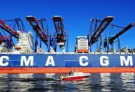 1150_1138 Das Containerschiff CMA CGM CHRISTOPHE COLOMB liegt am Burchardkai des Hamburger Hafens unter den weit ausladenden Containerbrcken des HHLA Container Terminals - ein Sportboot fhrt durch den Waltershofer Hafen, einem der Hafenbecken im Hamburger Hafengebiet. Der Hamburger Hafen hat eine Flche von 7236 Hektar. Er ist der grte Seehafen in Deutschland und, nach den Hfen von Rotterdam und Antwerpen, der drittgrte in Europa. Der Hafen bietet 320 Liegepltze fr Seeschiffe an 35 Kilometer Kaimauer, davon 38 Groschiffsliegepltze fr Container- und Massengutschiffe sowie 97 Liegepltze an Dalben. Bei Containerschiffen wird die Lade- bzw. Stellplatzkapazitt in Anzahl der Container angegeben. Maeinheit ist die TEU (Twenty-foot Equivalent Unit). Damit ist ein Standard-Container von 20 Fu Lnge gemeint. Ein Containerschiff mit 6.000 TEU verfgt also ber Stellpltze fr 6.000 20-Fu-Container, bei optimaler Verteilung der Gewichte der einzelnen Container.