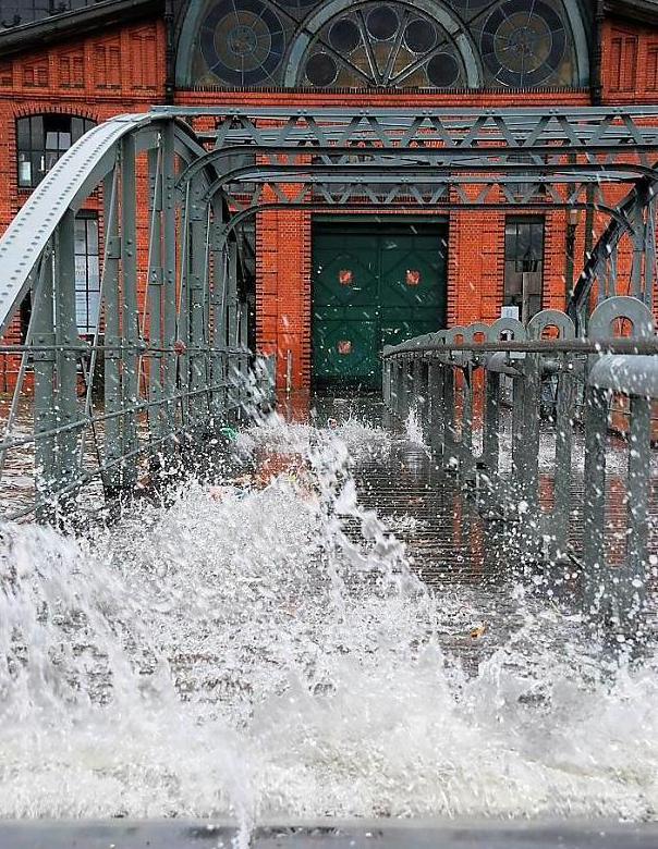 3517_0003 Blick ber die Wassertreppe am Fhranleger Altonaer Fischmarkt zur Eingangstr der Fischauktionshalle. Hoch spritz die Gischt der Wellen durch den Boden der Treppe. Das Hochwasser einer Sturmflut setzt immer den Fischmarkt und die umliegenden Strassen unter Wasser - von einer Sturmflut wird gesprochen, wenn der Tidenhchststand das mittlere Tidenhochwasser um 1,50 Meter oder mehr bersteigt. Ab 2,50 Meter wird von einer schweren Sturmflut und ab 3,50 Meter wird von einer sehr schweren Sturmflut gesprochen. 