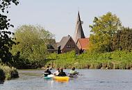 10000_2529 Kanus auf der Este bei Estebrgge - Kirchturm der St. Martinikirchen. Die 44,7 km lange Este ist ein linker Nebenfluss der Elbe in Niedersachsen und Hamburg - Die untere Este ist von der Mndung bis zum Unterwasser der Schleuse am Buxtehuder Hafen eine Bundes- wasserstrae der Klasse I, auf der die Seeschifffahrtsstraen-Ordnung gilt. Bis in die erste Hlfte des 20. Jahrhunderts wurde die Este als Transportweg fr Lastkhne und Schuten genutzt.