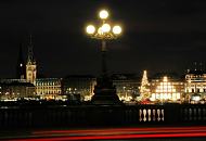 089_1277 Lombardsbrcke bei Nacht - die Rcklichter fahrender Autos hinterlassen bei der Langzeitaufnahme rote Lichtstreifen. Die historische Kandelaber auf der historischen Hamburger Brcke ist mit leuchtenden Kugelglsern versehen. Im Hintergrund auf der Binnenalster die Weihnachtstanne / Alstertanne - die Geschfte und Kaufhuser am Jungfernstieg sind hell erleuchtet; lks. das Gebude des Hamburger Rathauses, auf dem Rathausmarkt findet ein groer Weihnachtsmarkt statt. 