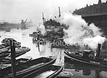 173_3502 Frachter liegen am Sandtorkai, Schute haben lngsseits fest gemacht - ein Schlepper unter Dampf kommt vom Brooktorhafen und fhrt in den Sandtorhafen ein. Vor dem Kaiserkai wird ein Kohleheber von zwei Schleppern gezogen - im Hintergrund die Silhouette vom Kaiserspeicher und die Mndung des Hafenbeckens in die Elbe.