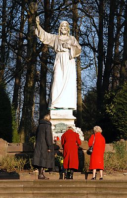 011_25883 | die Statue "Predigender Christus" wurde 1905 aus Marmor gefertigt; Bildhauer Xaver Arnold. Friedhofs - Besucherinnen stehen vor der Skulptur und znden Kerzen an.